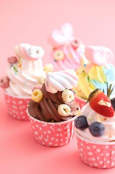 Colorful cupcakes isolated in pink background