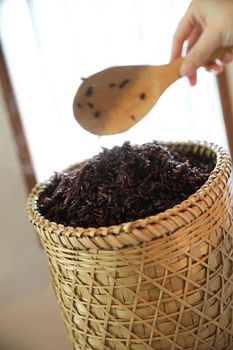 Boiled riceberry rice on Wicker basket with spoon in close up