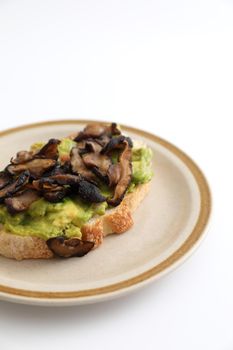 Toast with avocado and grilled mushroom in white background