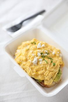 Avocado and scrambled eggs toast with delivery package in white background