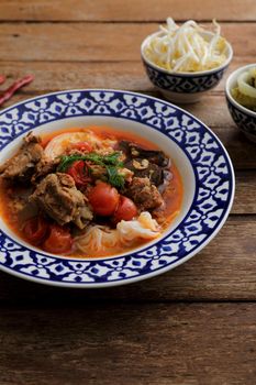 Local northern thai food Rice noodles with pork in spicy soup in wood background