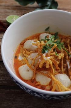 Local northern Thai food Egg noodle curry with meatballs on wood background