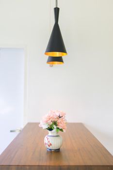 pink flower in jar on wood table with space for text