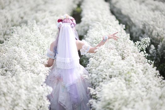 Portrait of Asian young woman with lolita fashion dress in white flower garden background