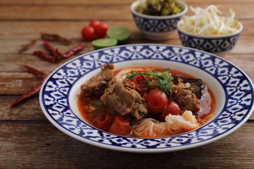 Local northern thai food Rice noodles with pork in spicy soup in wood background