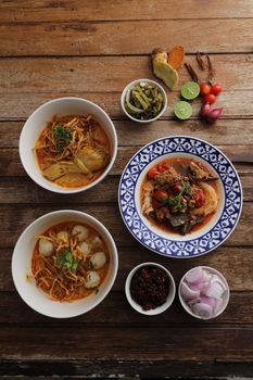 Local northern Thai food Egg noodle curry with chicken and meatball and Rice noodles on wood background