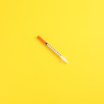 Syringe vaccine isolated in yellow background