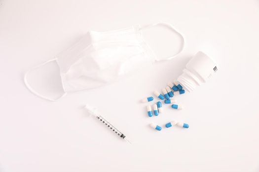 Syringe with pill and mask isolated in white background