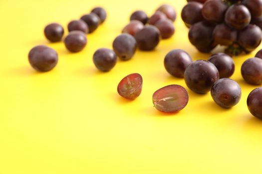 Red grapes isolated in yellow background