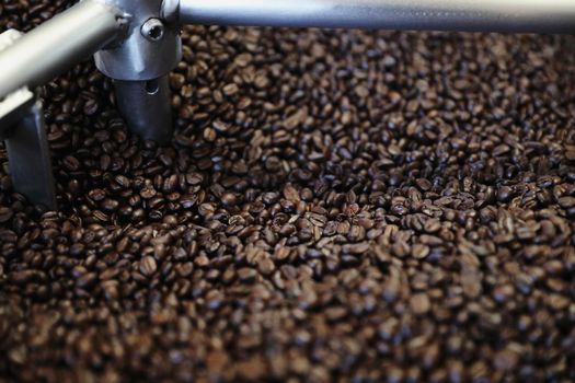 Coffee beans roasting with machine in close up