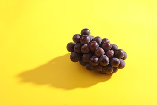 Red grapes isolated in yellow background