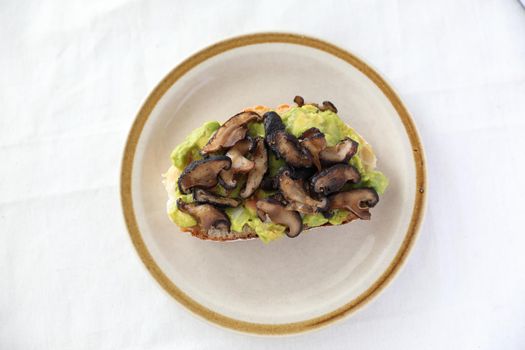 Toast with avocado and grilled mushroom in white background