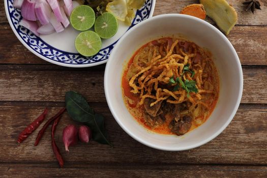 Local northern Thai food Egg noodle curry with beef on wood background