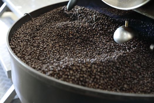 Coffee beans roasting with machine in close up