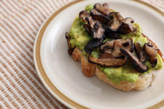 Toast with avocado and grilled mushroom in white background