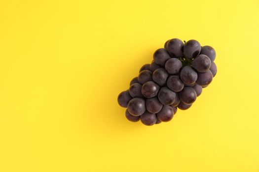 Red grapes isolated in yellow background