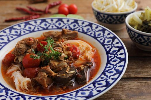 Local northern thai food Rice noodles with pork in spicy soup in wood background