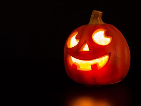 Lit jack-o'-lantern on black background.