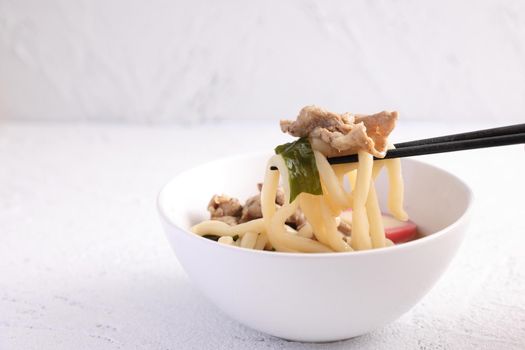 Udon noodles with pork isolated in white background