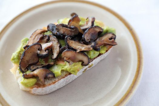 Toast with avocado and grilled mushroom in white background
