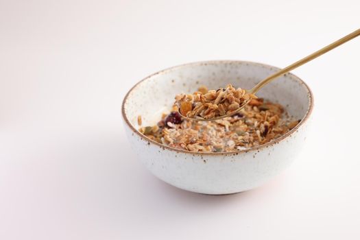 granola with milk with spoon isolated in white background