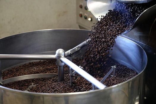 Coffee beans roasting with machine in close up
