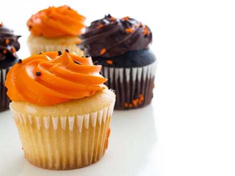 Halloween orange and black cupcakes on white background.