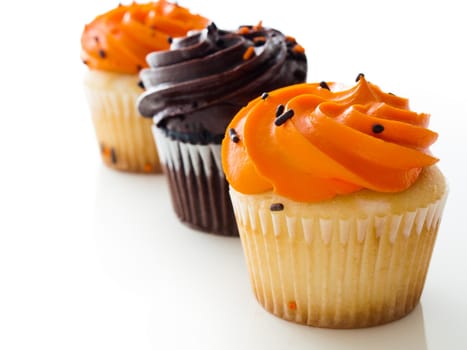 Halloween orange and black cupcakes on white background.