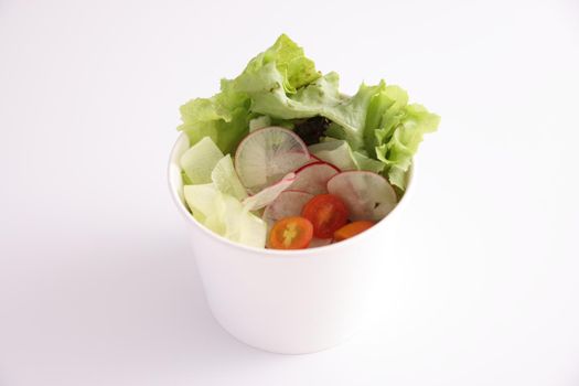 Salad in plastic package for take away or food delivery isolated on white background
