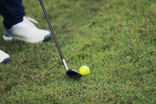 Golf ball on green grass ready to be struck on grass background