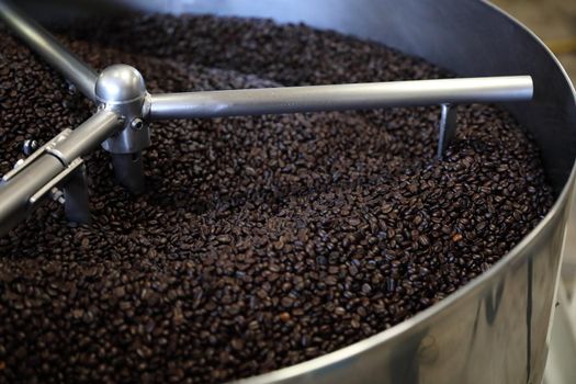 Coffee beans roasting with machine in close up