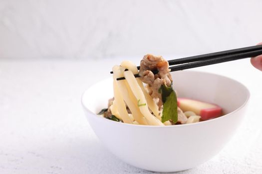 Udon noodles with pork isolated in white background