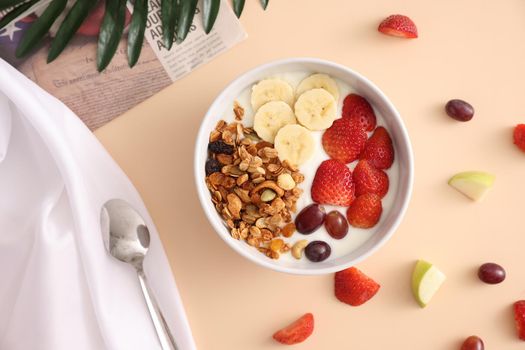 bowl of granola cereal with yogurt and berries isolated on eggnog color background