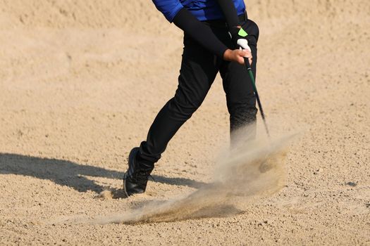 Young male golfer player on sand golf course