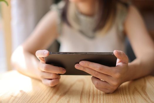 Woman hand using a smartphone for Stock exchange trading online in the coffee shop, business concept