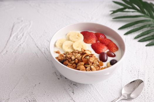 bowl of granola cereal with yogurt and berries isolated on white background