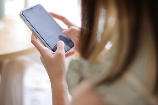 Woman hand using a smartphone for Stock exchange trading online in the coffee shop, business concept