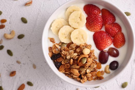 bowl of granola cereal with yogurt and berries isolated on white background