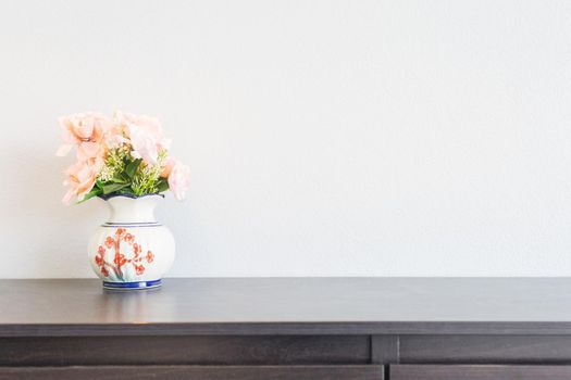 pink flower in jar on wood table with space for text