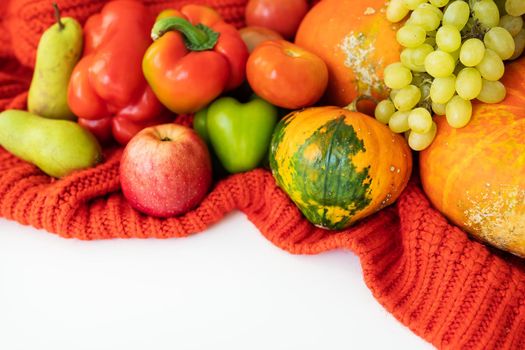 Thanksgiving Day. Big autumn harvest - pear, apples, pumpkin, pepper, tomato on a white background and red cloth. Thanksgiving celebration concept