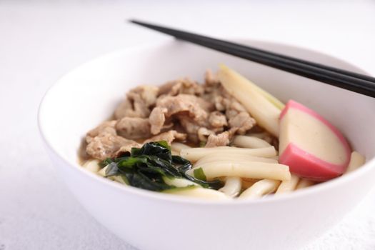 Udon noodles with pork isolated in white background