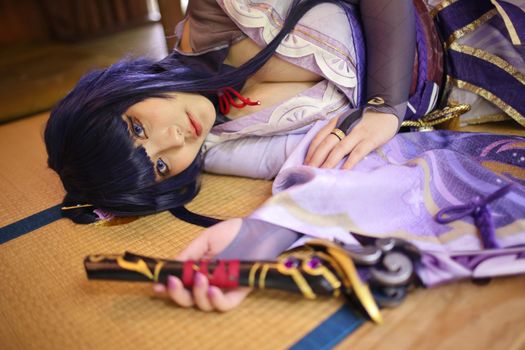 Portrait of a beautiful young woman game cosplay with samurai dress costume sleeping at japanese room