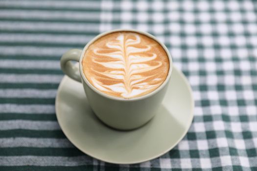 hot cappuccino with latte art on wood background