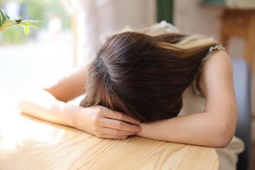 Young Asian woman resting with sleeping in a coffee shop