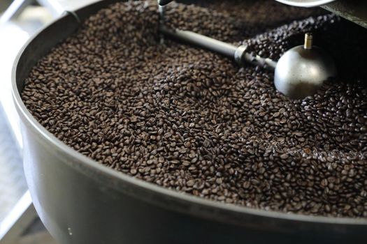 Coffee beans roasting with machine in close up