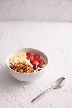 bowl of granola cereal with yogurt and berries isolated on white background