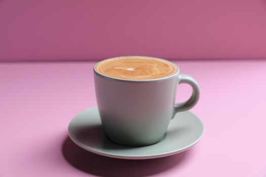 hot cappuccino with latte art isolated in pink background