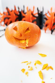 October 31. Halloween holiday. The carved face of a pumpkin on an orange and black background