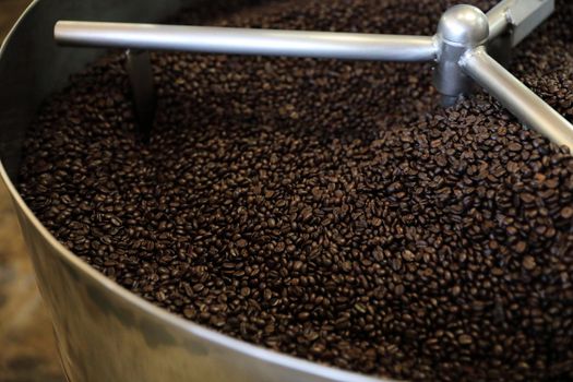 Coffee beans roasting with machine in close up