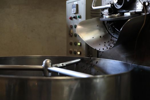 Coffee beans roasting with machine in close up